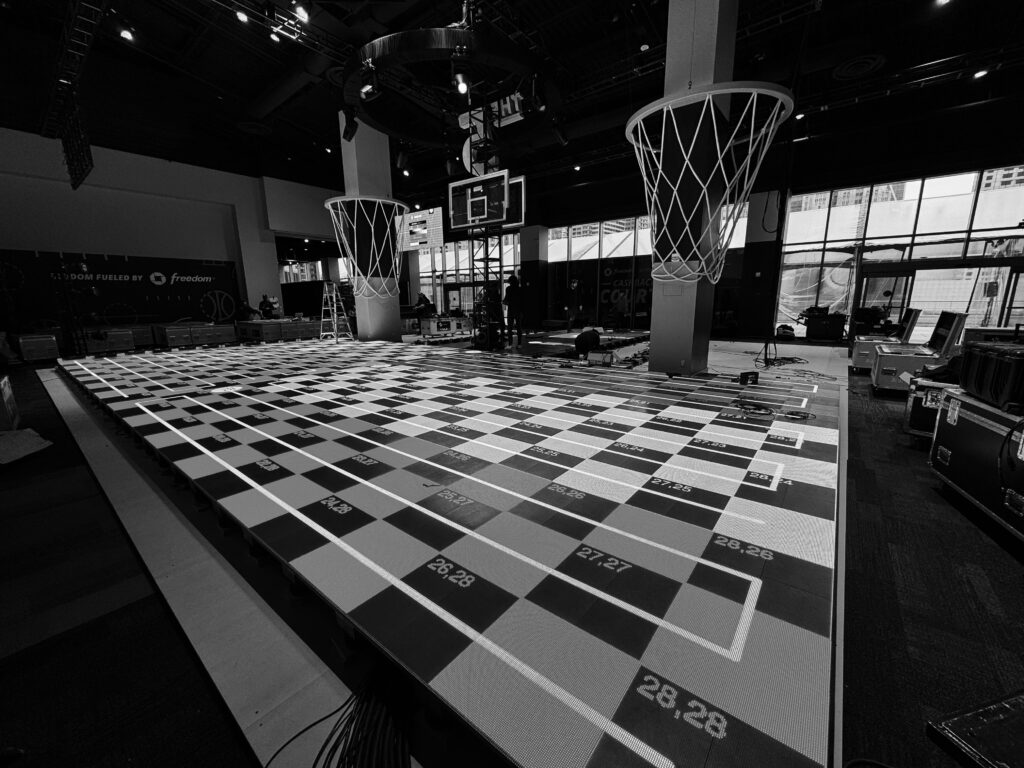 A black-and-white view of the basketball court displaying a test pattern during setup.
