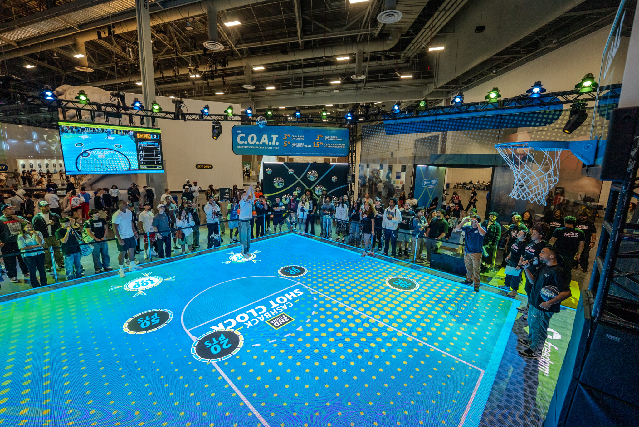 Visitors surround an illuminated basketball court at the Chase ComplexCon activation.