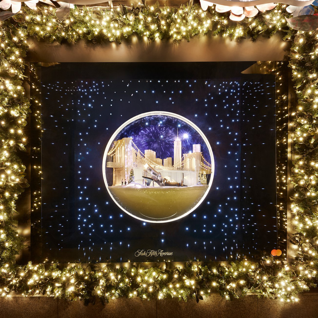 A Dior holiday window shows an illuminated golden scene inside a circular frame.