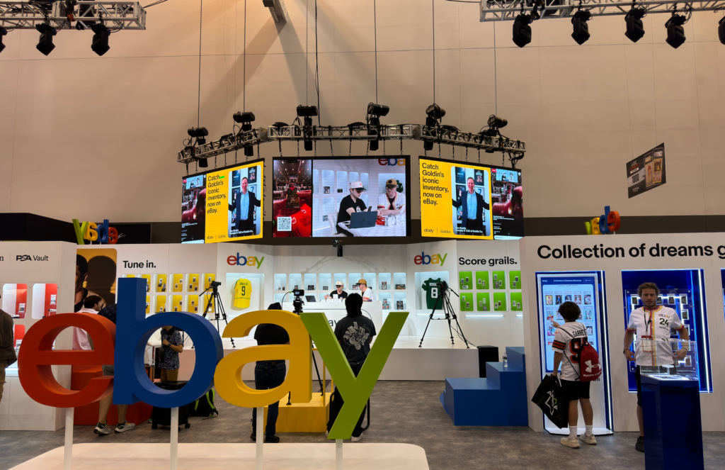 A suspended multi-sided video display above the colorful eBay exhibition booth.