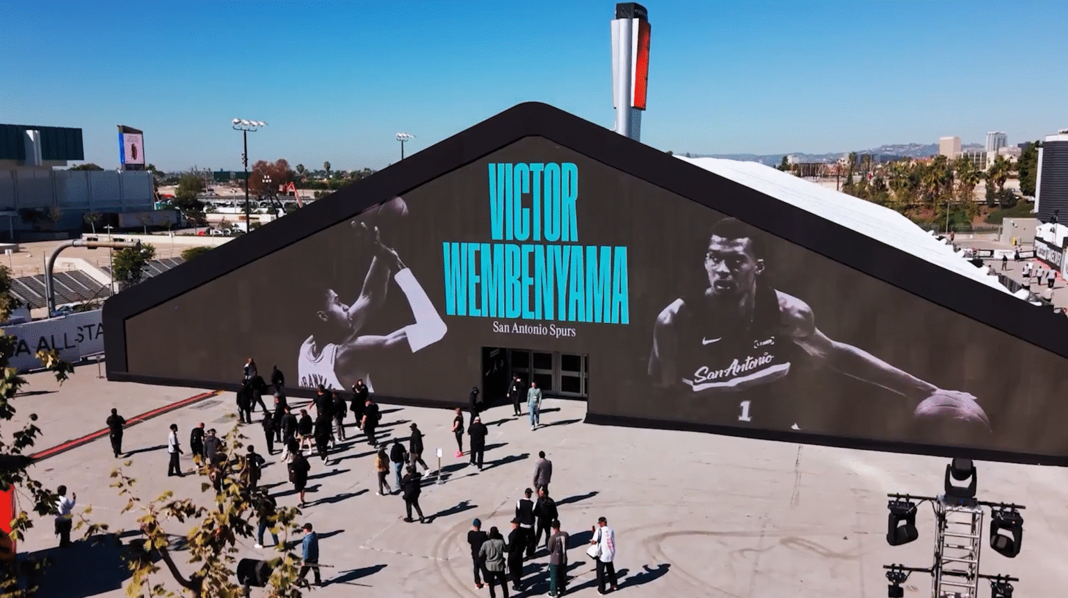 Visitors outside a pavilion with a large basketball display at Footlocker ASW 2026.