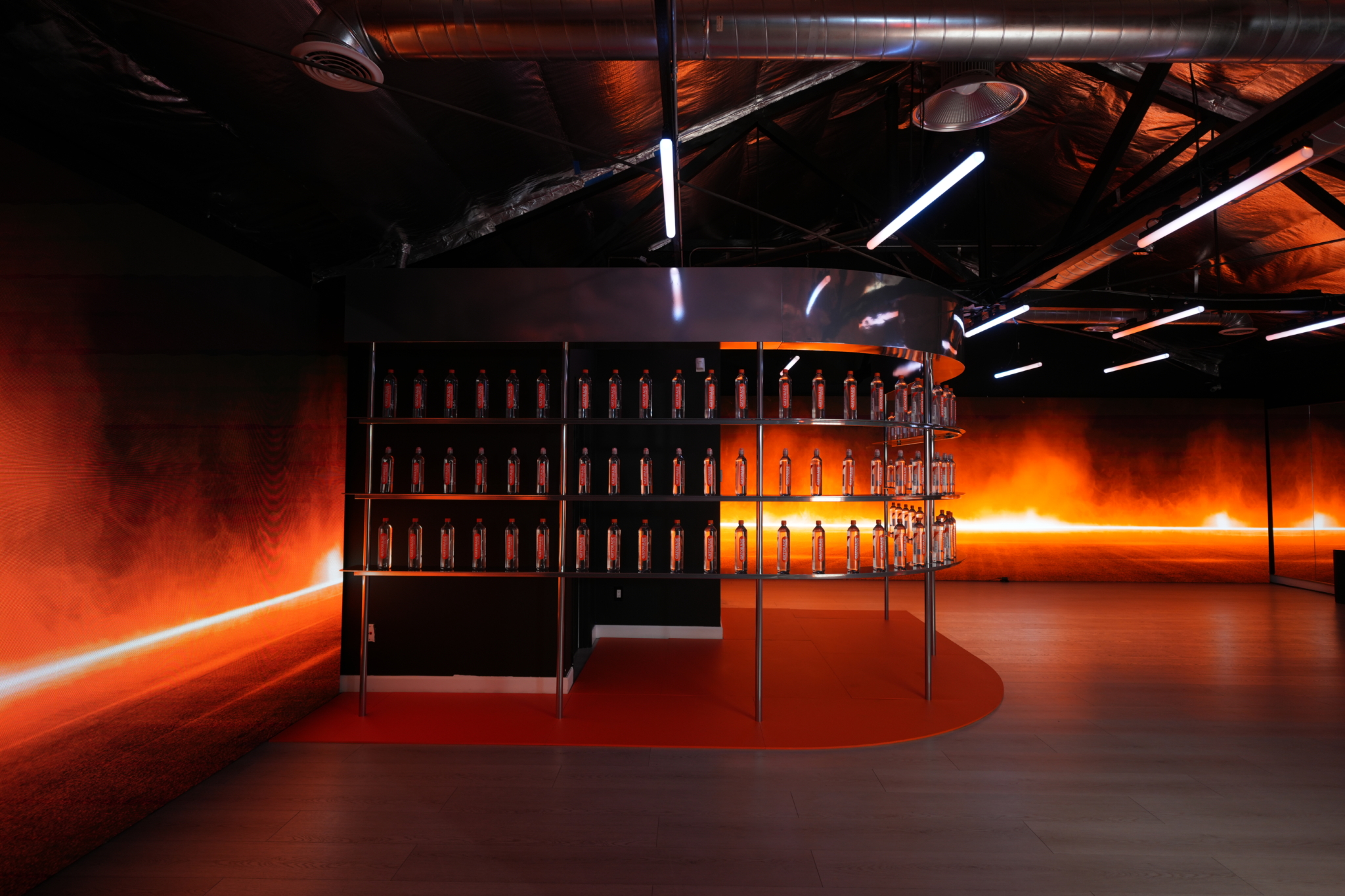 Orange wall lighting surrounds a circular product display at the Gatorade activation.