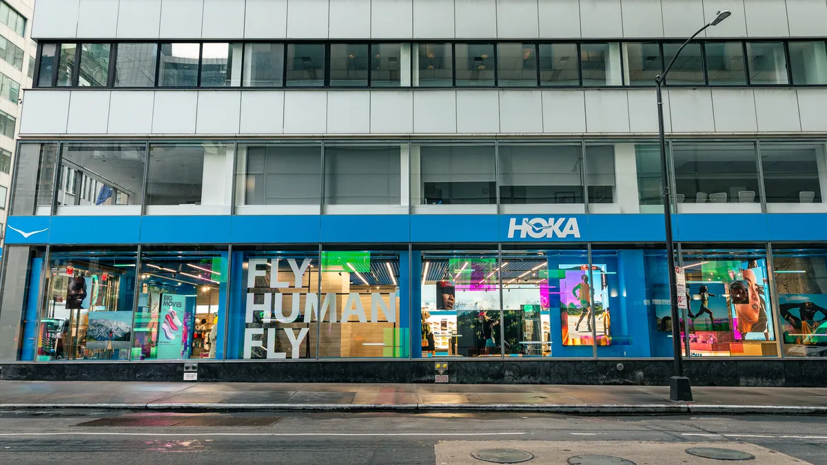 HOKA's blue storefront with colorful digital displays visible through its windows.
