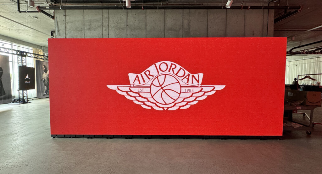 A large red digital wall displays the Air Jordan logo.