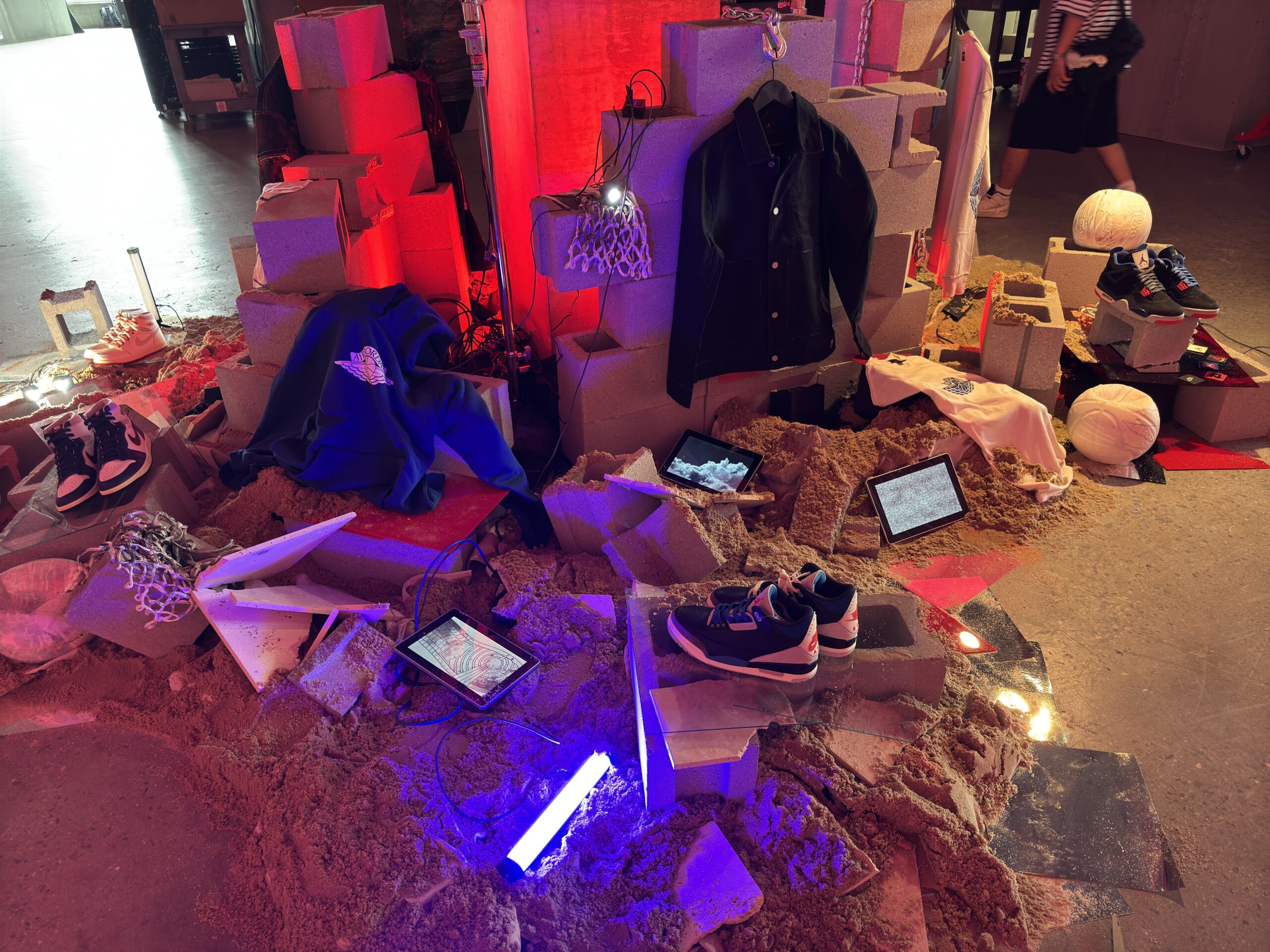 Jordan clothing and footwear displayed among colored illuminated props.