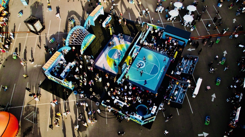 An overhead view of a blue basketball court and surrounding visitors at the JPMC activation.