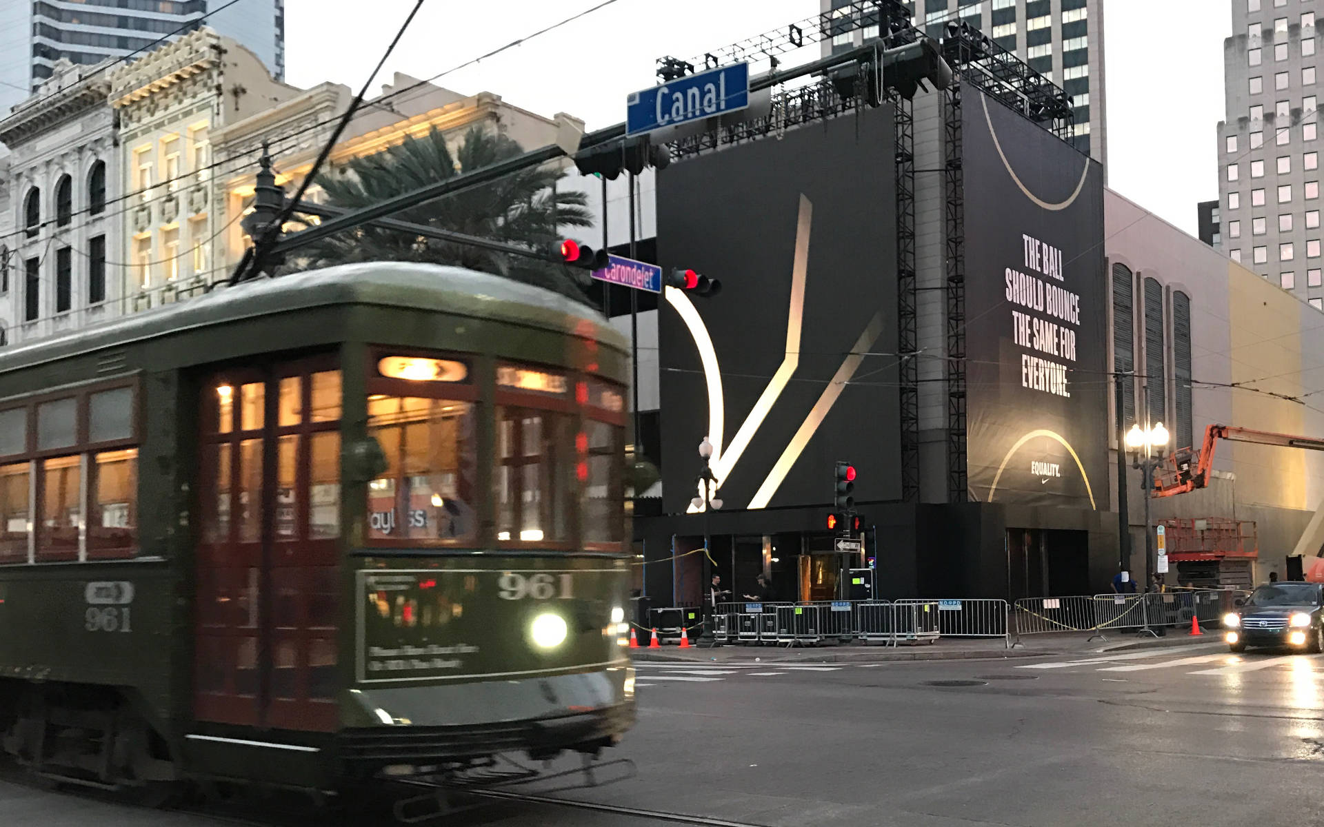 A streetcar passes a large Nike-branded outdoor display in New Orleans.
