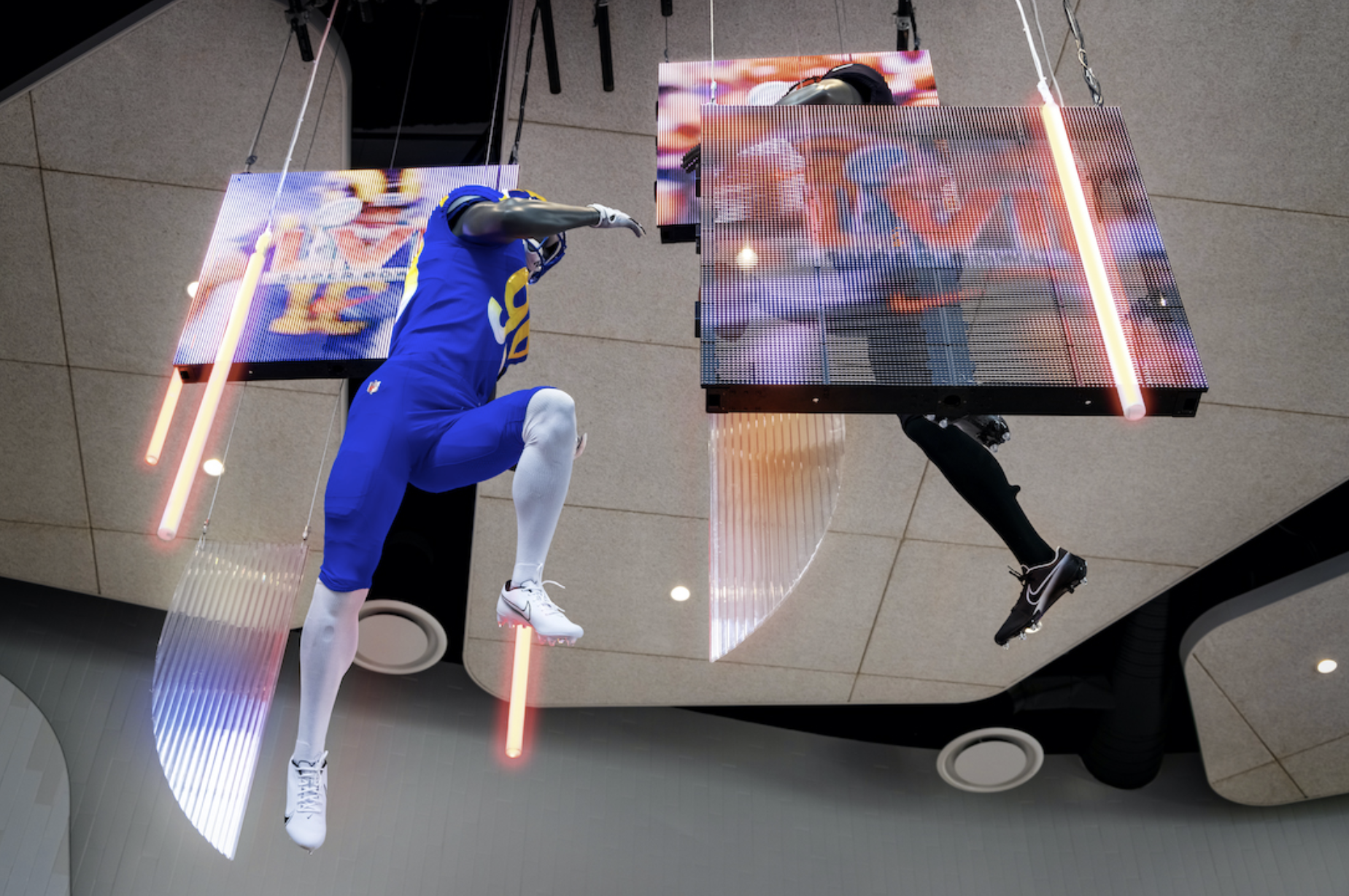 Suspended athlete figures and digital screens in Nike's Super Bowl LVI retail display.