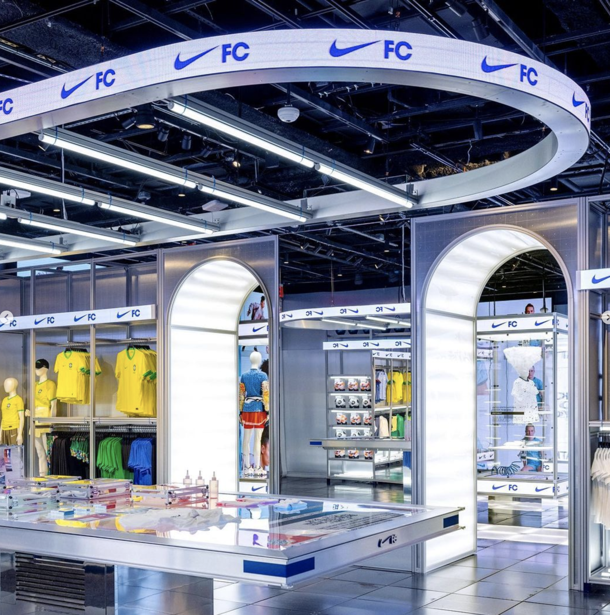 A curved overhead display and illuminated retail fixtures at Nike's Women's World Cup activation.