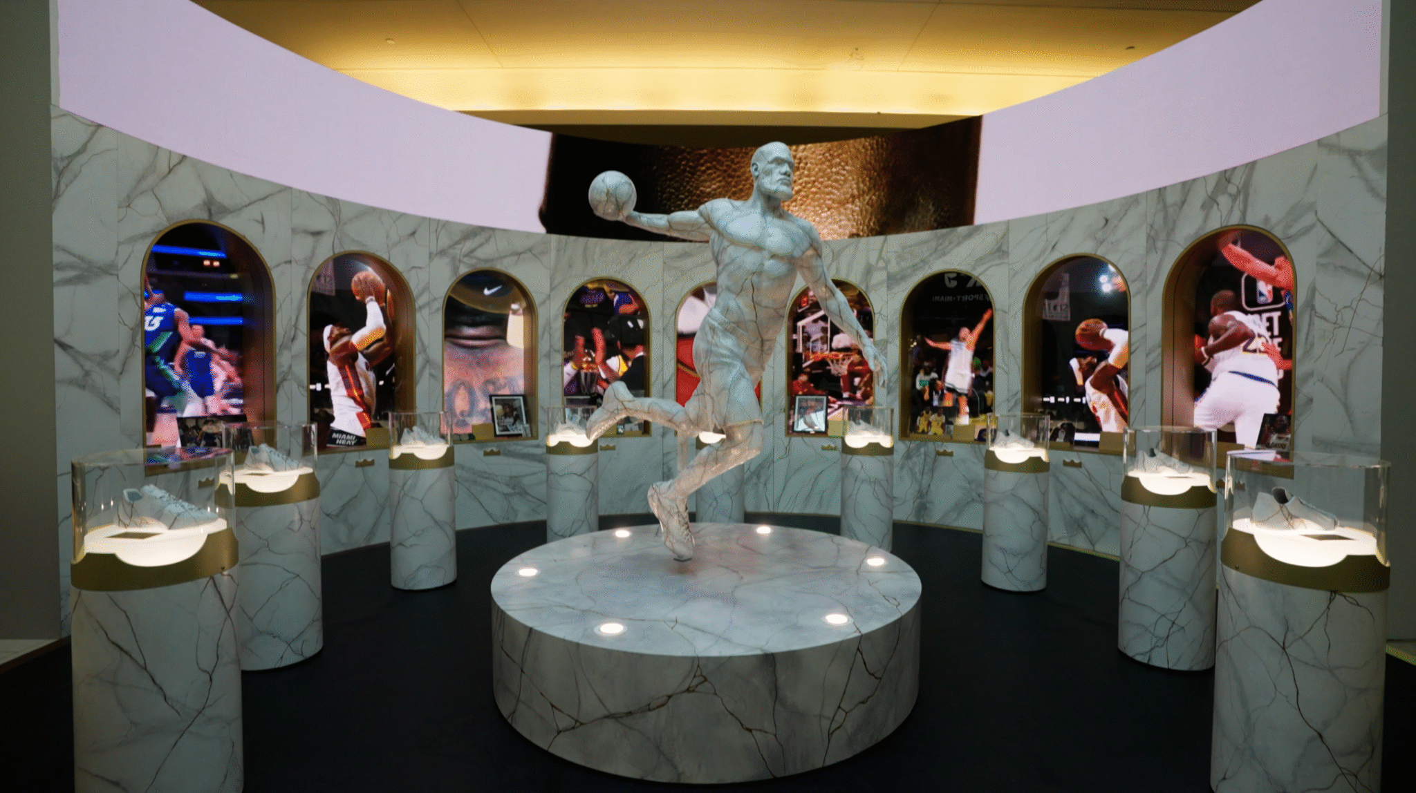 A basketball statue stands among illuminated alcoves in the Nike x LeBron Forever King experience.