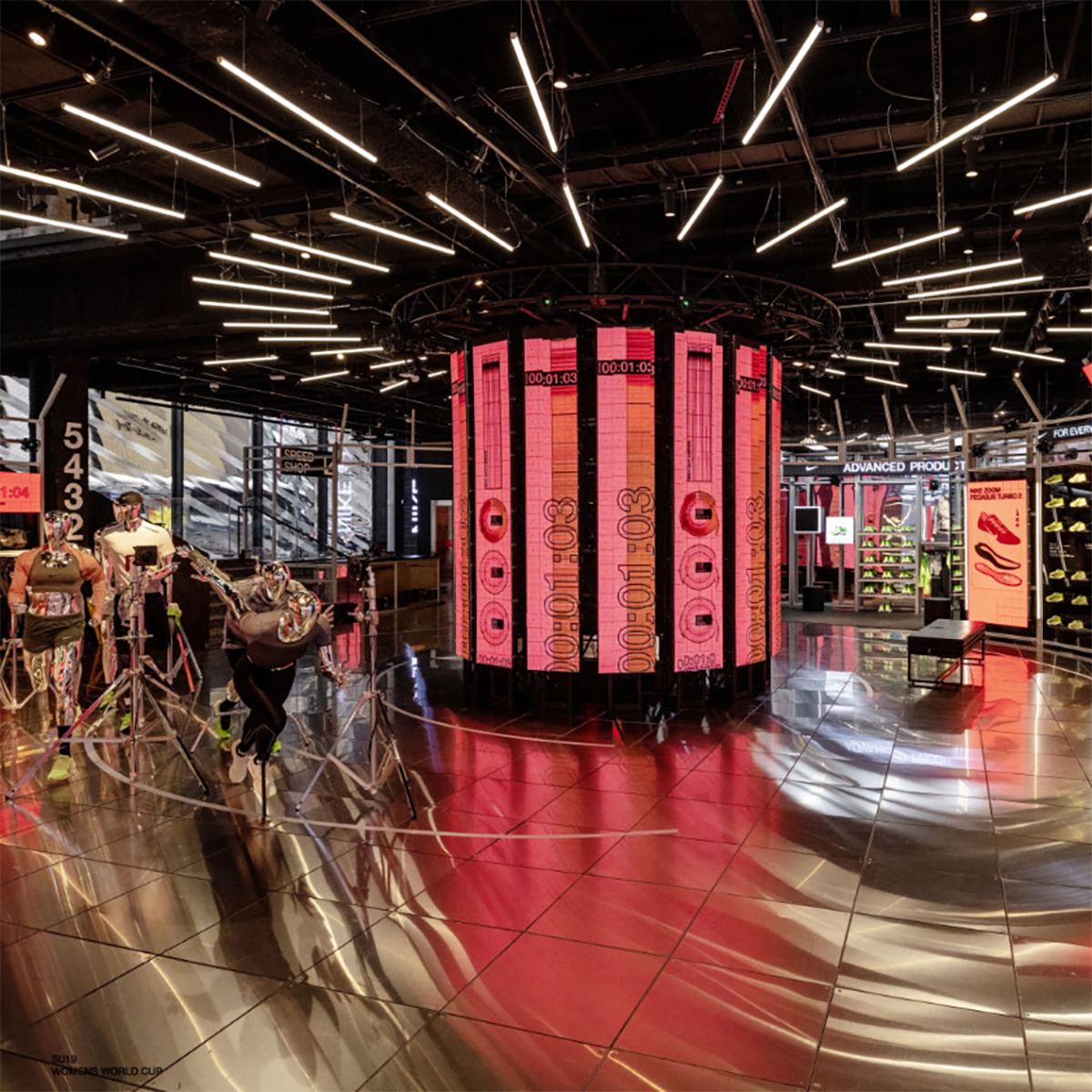 A circular column of pink digital displays in the Nike Zoom retail space.