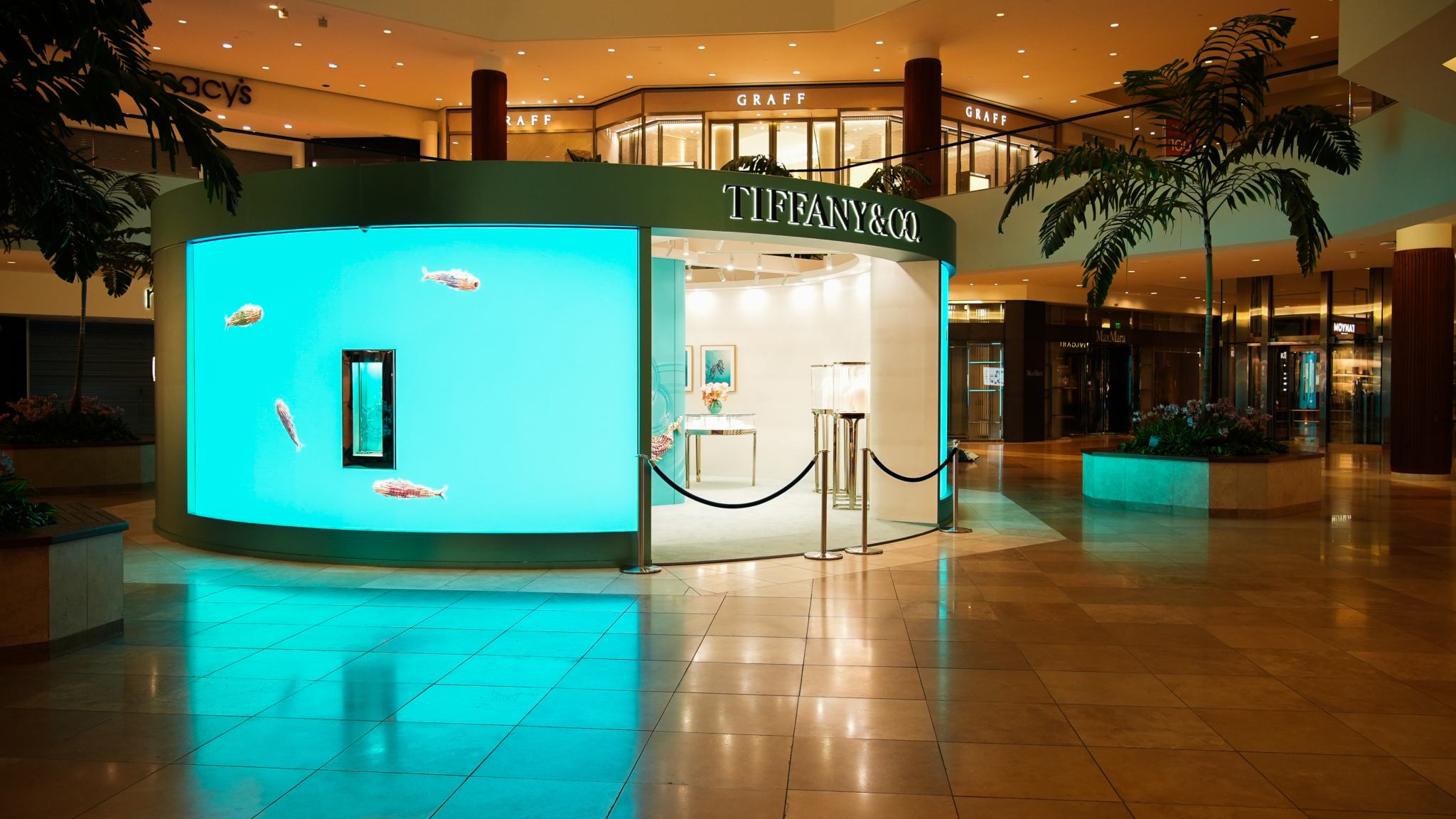 A turquoise illuminated Tiffany & Co pop-up display in a shopping center.