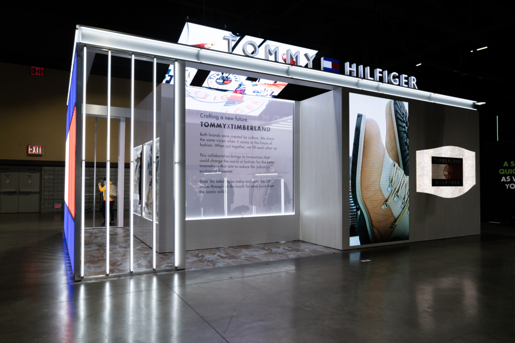 Illuminated vertical bars frame the entrance to the Tommy Hilfiger pavilion.